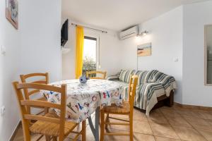 jadalnia ze stołem, krzesłami i kanapą w obiekcie Apartments with a parking space Baska, Krk - 13907 w Bašce