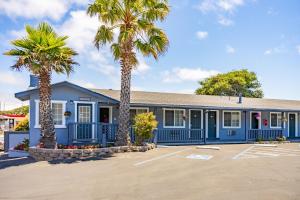 a blue building with palm trees in a parking lot at The Monterey Fireplace Inn in Monterey