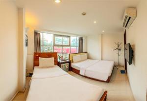 Cette chambre comprend 2 lits et une télévision. dans l'établissement Nu Hotel - 18 Bui Vien Walkstreet, à Hô-Chi-Minh-Ville