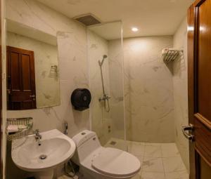 La salle de bains est pourvue de toilettes, d'un lavabo et d'une douche. dans l'établissement Nu Hotel - 18 Bui Vien Walkstreet, à Hô-Chi-Minh-Ville