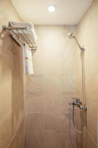 La salle de bains est pourvue d'une douche et de serviettes. dans l'établissement Nu Hotel - 18 Bui Vien Walkstreet, à Hô-Chi-Minh-Ville