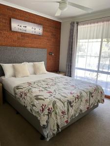 a bedroom with a bed and a brick wall at Greenways Holiday Units in Tocumwal +11 photos