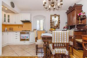una cocina con armarios blancos y una mesa con sillas. en House Stone house in center en Jelsa
