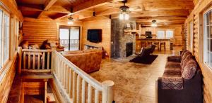 a living room with a fireplace in a log cabin at Backwoods Bonanza - Big Cabin With Hot Tub! in Duck Creek Village