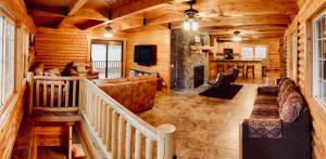 ein Wohnzimmer mit Kamin in einer Blockhütte in der Unterkunft Backwoods Bonanza - Big Cabin With Hot Tub! in Duck Creek Village