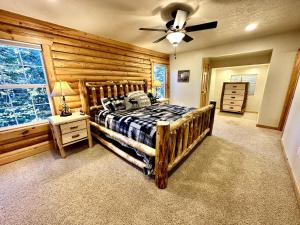 a bedroom with a bed and a ceiling fan at Backwoods Bonanza - Big Cabin With Hot Tub! in Duck Creek Village