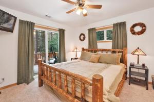 a bedroom with a bed and a ceiling fan at Fawnskin Log Cabin- Luxurious Group Log Cabin Estate- Hot Tub- Walk to Lake in Fawnskin