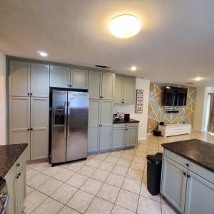 a large kitchen with a stainless steel refrigerator at Amazing palm villa house in Riverside