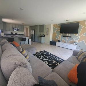 a living room with a couch and a kitchen at Amazing palm villa house in Riverside