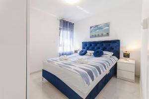 a blue bed with a blue headboard in a bedroom at Apartments Ella in Vodice