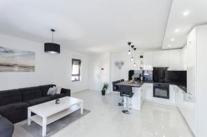 a white living room with a couch and a table at Apartments Ella in Vodice