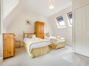 two beds in a room with white walls and windows at The Knock in Inverey