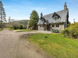 an old house with a dirt road in front of it at The Knock in Inverey