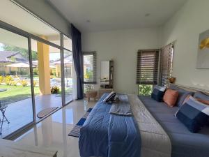 ein Wohnzimmer mit einem großen Bett und einem großen Fenster in der Unterkunft Pool Villa, Resort, Mae Ramphueng Beach, Ban Phe, Rayong, Residence M Thailand in Ban Chamrung