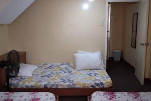 een slaapkamer met een bed met kussens erop bij 4 Bedroom Apartment 15pax Moran in Baguio