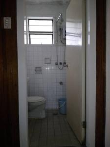 baño pequeño con aseo y ventana en 4 Bedroom Apartment 15pax Moran, en Baguio