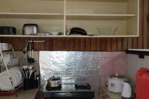 een keuken met een kookplaat en een oven bij 4 Bedroom Apartment 15pax Moran in Baguio