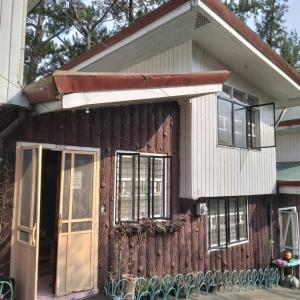 een huis met een deur en stoelen ervoor bij 4 Bedroom Apartment 15pax Moran in Baguio