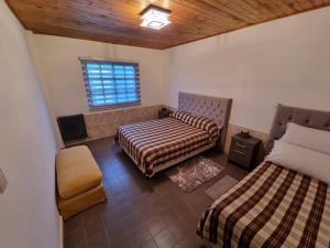 1 Schlafzimmer mit 2 Betten, einem Stuhl und einem Fenster in der Unterkunft Departamento por día in Río Gallegos