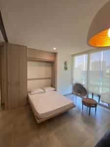 a bedroom with a bed and a table and a chair at El Samario Cumbia Host-Playa Salguero- Santa Marta in Gaira