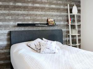 a bedroom with a white bed with a brick wall at Holiday home Halmstad VII in Halmstad