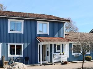 uma casa azul com um telhado vermelho em Holiday home Halmstad VII em Halmstad