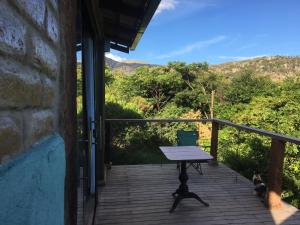 a porch with a picnic table and two cats on it at Casas da Paty in Santana do Riacho