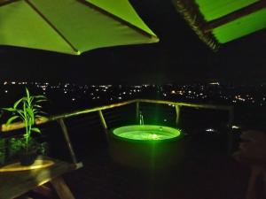 a bathroom with a green tub on a balcony at night at Glamping Orosierra in Chinchiná
