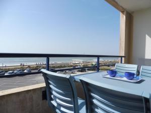 - une table avec des chaises et une vue sur la plage dans l'établissement Appartement Notre-Dame-de-Monts, 2 pièces, 2 personnes - FR-1-540-211, à Notre-Dame-de-Monts