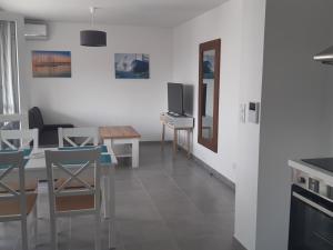 eine Küche und ein Wohnzimmer mit einem Tisch und einem TV in der Unterkunft Appartement Port Leucate, 2 pièces, 4 personnes - FR-1-727-6 in Port Leucate