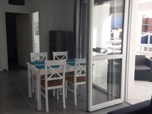 ein Esszimmer mit einem Tisch, Stühlen und einem Fenster in der Unterkunft Appartement Port Leucate, 2 pièces, 4 personnes - FR-1-727-6 in Port Leucate