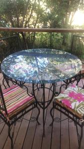 szklany stół na tarasie z dwoma krzesłami w obiekcie Casas da Paty w mieście Santana do Riacho