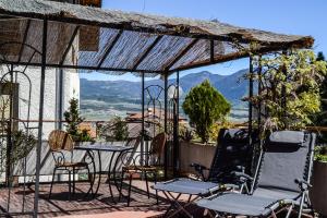 patio con mesa, sillas y vistas en Agritur de Poda Apartments, en Flavon