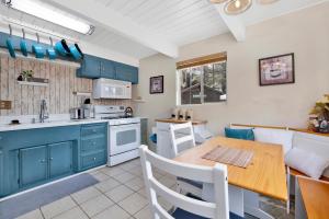 a kitchen with blue cabinets and a wooden table at Tinker Bell Gambrel by Big Bear Vacations Ultra Relaxing Bear City Retreat in Big Bear City