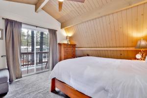 a bedroom with a white bed and a large window at Tinker Bell Gambrel by Big Bear Vacations Ultra Relaxing Bear City Retreat in Big Bear City