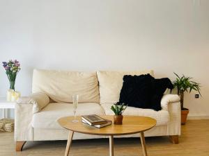 un soggiorno con divano bianco e tavolo di Apartamento anida a Granada