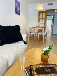 Apartamento anida في غرناطة: غرفة معيشة مع طاولة مع كأس من النبيذ