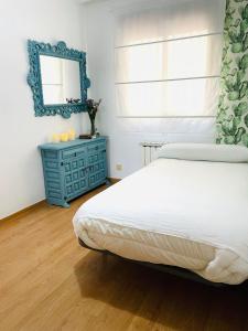 a bedroom with a bed and a blue dresser and a mirror at Apartamento anida in Granada