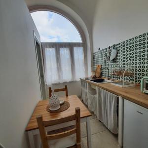 une cuisine avec une table et un évier ainsi qu'une fenêtre. dans l'établissement Holiday house-Amalfi Coast Tramonti-Come una Volta, à Tramonti