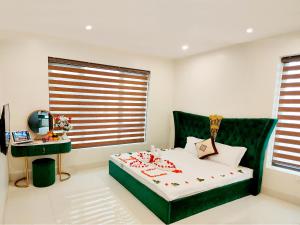 a bedroom with a green bed and a desk at Villa FLC Sam Son Lavender in Sầm Sơn