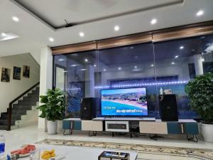 sala de estar con TV de pantalla plana grande en Villa FLC Sam Son Lavender, en Sầm Sơn