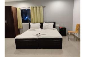 una camera da letto con un grande letto con lenzuola bianche e una finestra di Super Capital O Jubilee Banjara Suites Near City Center Mall a Hyderabad