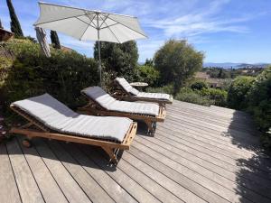 2 chaises longues et un parasol sur une terrasse en bois dans l'établissement Mas 2 chambres avec piscine, tennis, parking et wifi - FR-1-726-24, à La Croix-Valmer