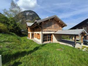 a house on a grassy hill with a building at Chalet Sixt-Fer-à-Cheval, 6 pièces, 13 personnes - FR-1-624-132 in Sixt