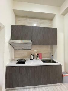 a kitchen with brown cabinets and a sink at Islandlife B&B in Huxi