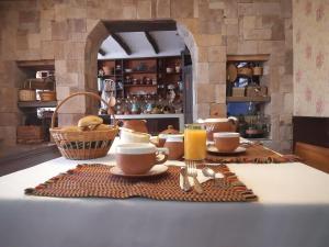 einen Tisch mit Tassen und Tellern und ein Glas Orangensaft in der Unterkunft Casona Del Rosario - Plaza de Armas in Chachapoyas