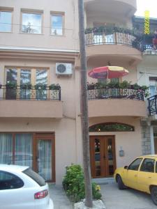 um carro amarelo estacionado em frente a um edifício com um guarda-chuva em Jovanoski Apartments em Struga