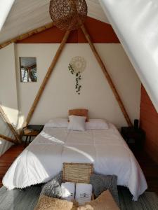 a bedroom with a white bed in a attic at Glamping Orosierra in Chinchiná