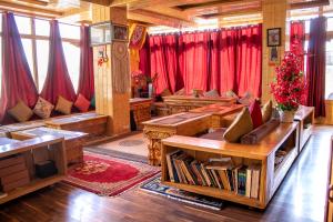 uma sala de estar com cortinas vermelhas e um sofá em Laksdup Guest House em Leh