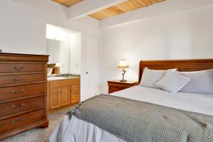 a bedroom with a bed and a dresser and a sink at Slopeside Views Chalet- Hot Tub- Resort View Cozy Condo in Big Bear Lake